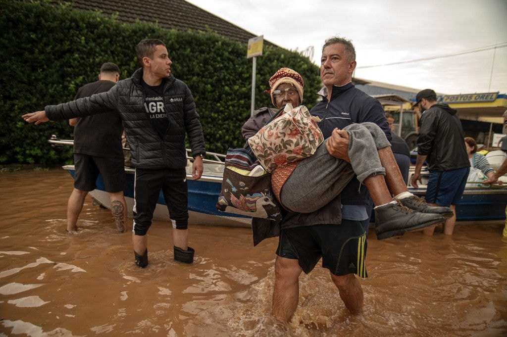 Moradores que estavam ilhados são resgatados por voluntários em Porto Alegre. Carlos Fabal/AFP