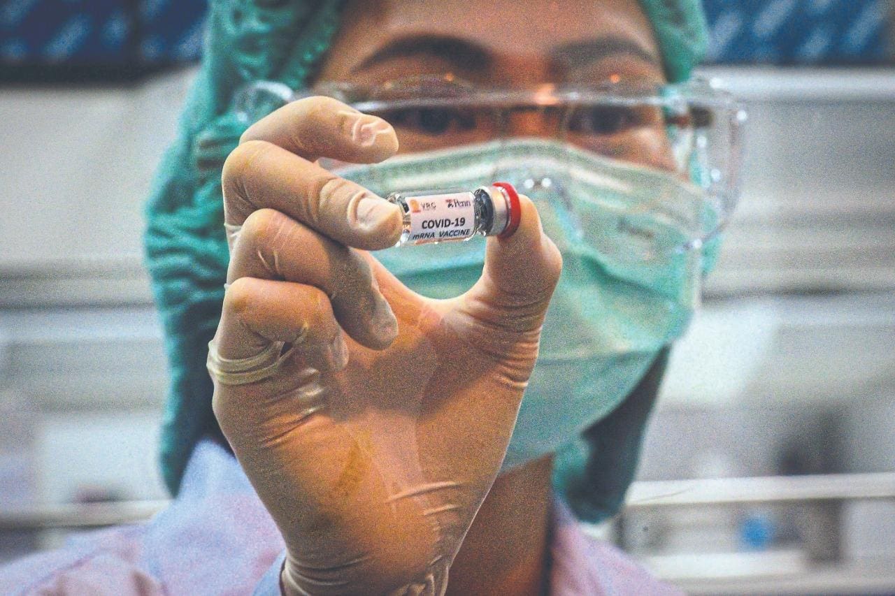 Cientista mostra ampola de vacina contra o novo coronavírus – uma das centenas que estão em desenvolvimento no mundo