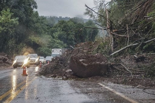 View of the partially blocked RS 129 road after flooding caused by heavy rains in Encantado, Rio Grande do Sul state, Brazil, on May 10, 2024. The skies opened once again Friday in southern Brazil, offering little respite for those whose homes have been swallowed by floodwaters, while the number of people forced to evacuate doubled in 24 hours. (Photo by Gustavo Ghisleni / AFP)