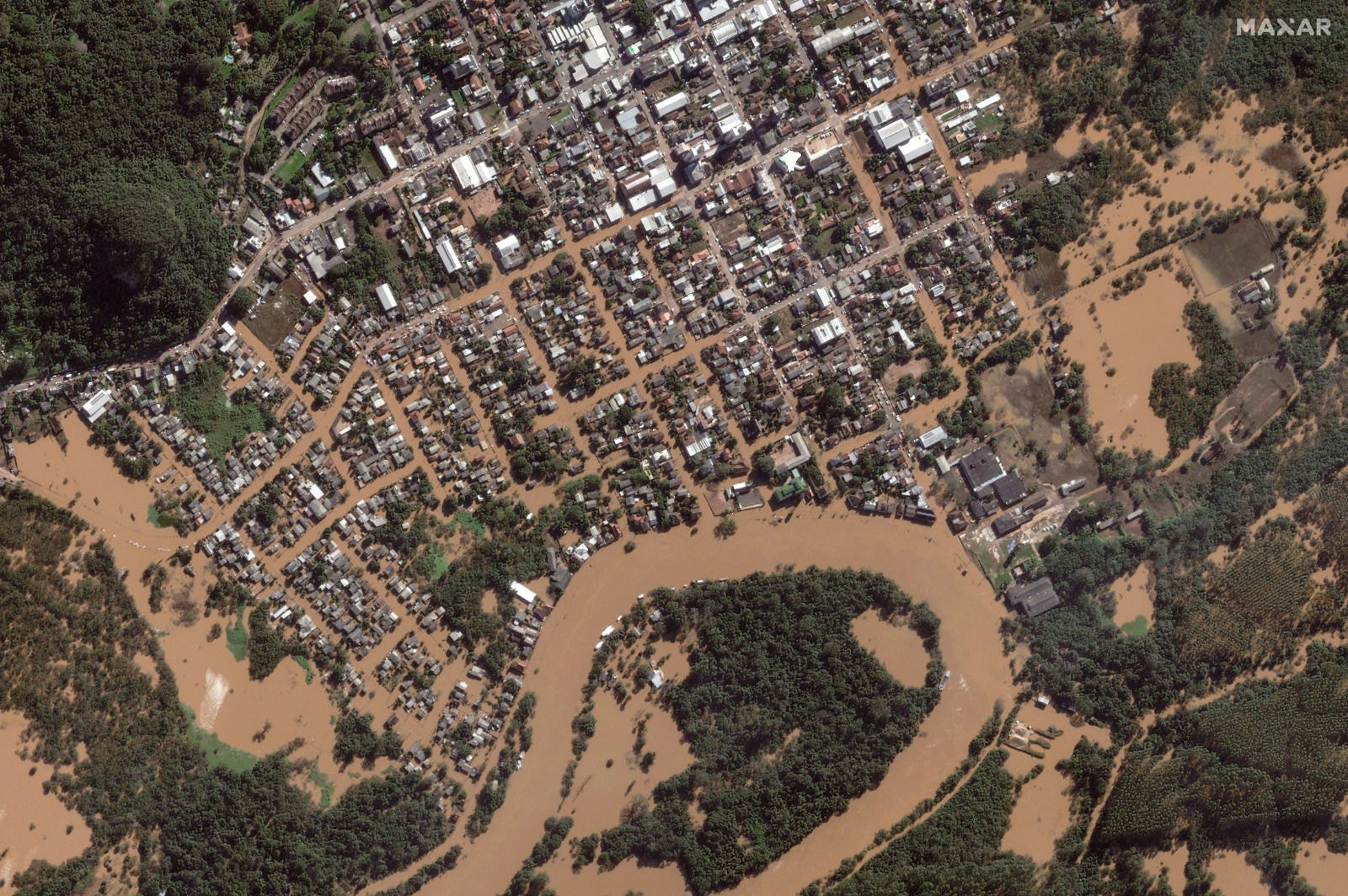 Imagem de satélite divulgada em 7 de maio de 2024 mostra bairro inundado localizado às margens do rio Caí, em Montenegro, no Rio Grande do Sul