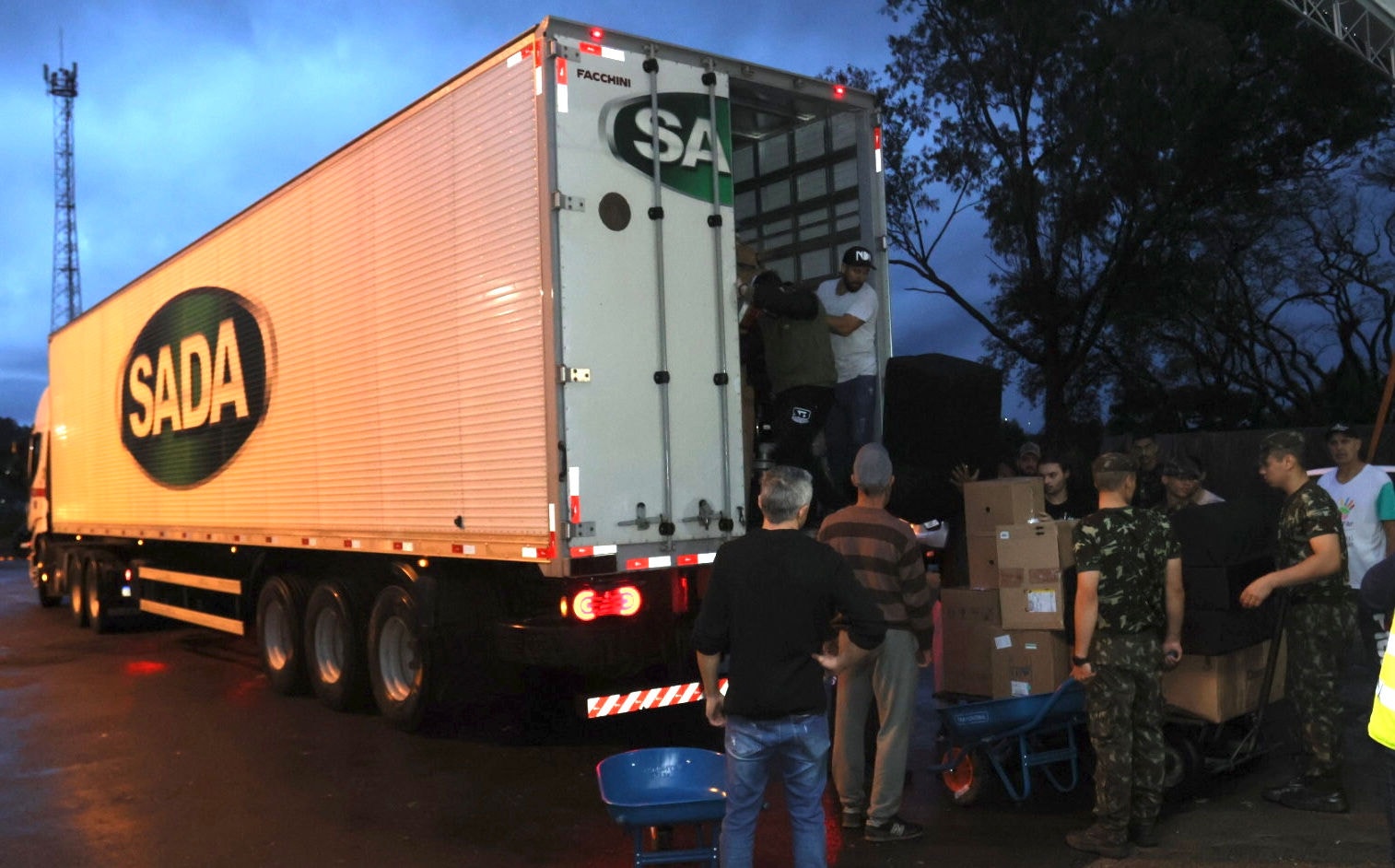 Os voluntários se revezaram para retirar tudo do baú do caminhão e levar para dentro do centro de distribuição. FOTO: Rodney Costa / O TEMPO