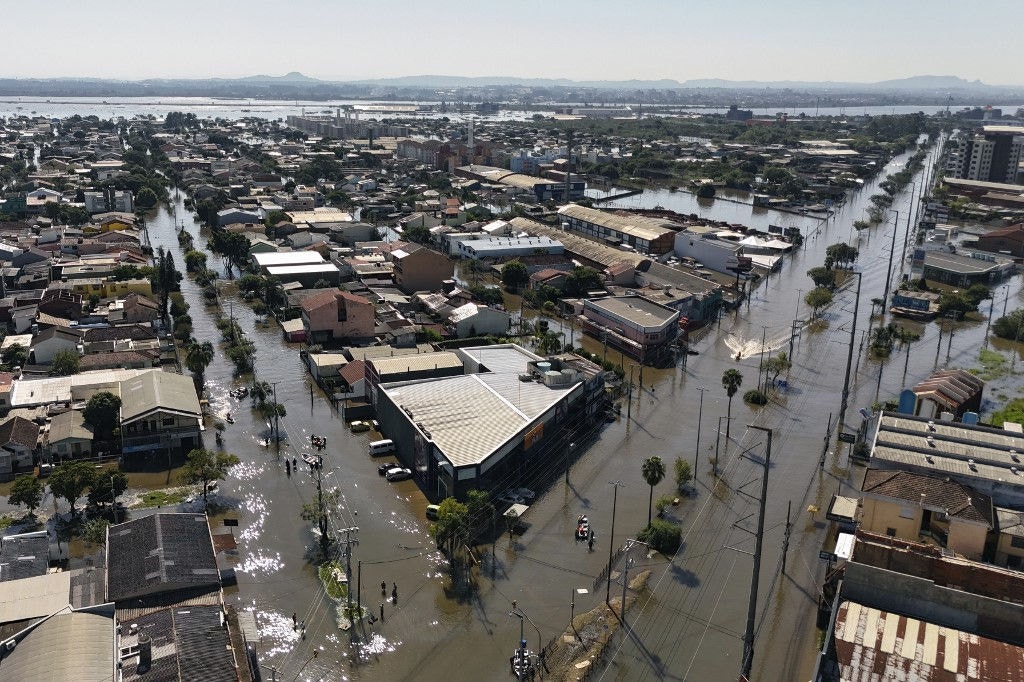Aerial view of flooded streets in Porto Alegre, Brazil, taken on May 6, 2024, after torrential storms in the southern Rio Grande do Sul State. The rains may have abated, but floodwaters on Monday continued their assault on south Brazil, with hundreds of municipalities in ruins and food and drinking water fast running out. Since the unprecedented deluge started last week, at least 83 people have died, 111 are missing and more than 129,000 were ejected from their homes by floods and mudslides in Rio Grande do Sul state, authorities said. (Photo by Carlos FABAL / AFP)