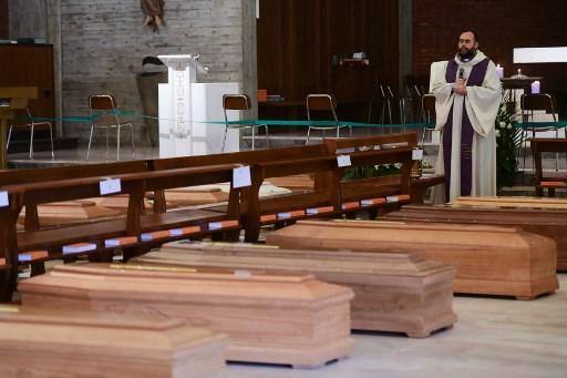 O padre Don Marcello dá uma bênção aos caixões das pessoas falecidas dentro da igreja de San Giuseppe em Seriate,