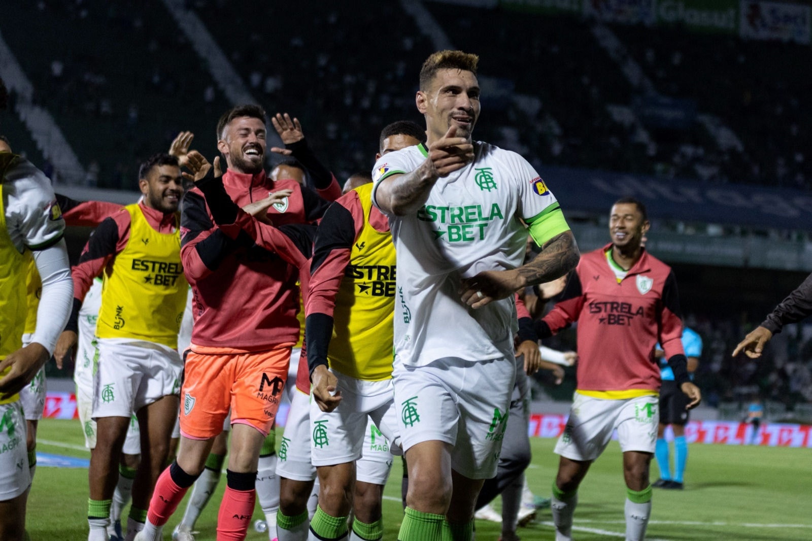 Moisés corre para o banco de reservas para comemorar com os companheiros após marcar o gol da vitória do América sobre o Guarani, em Campinas