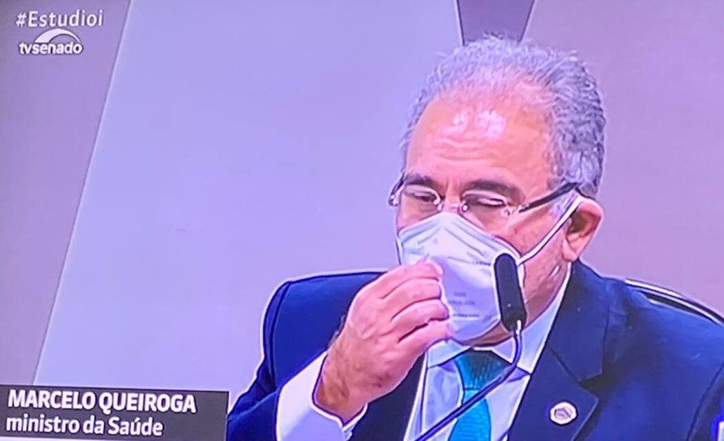 Marcelo Queiroga toca na parte frontal da máscara durante sabatina na CPI da Covid