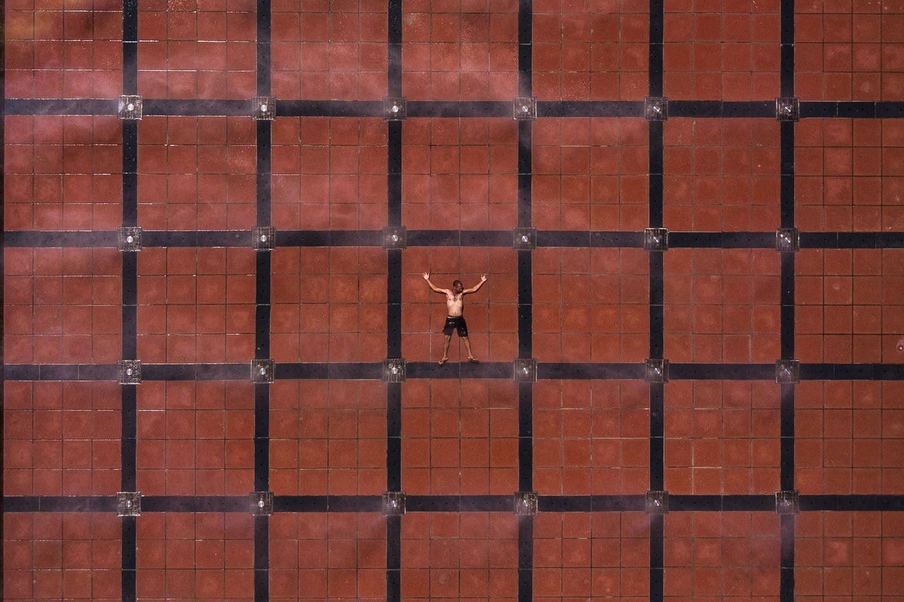 Homem se refresca em fontes da Praça da Estação.
