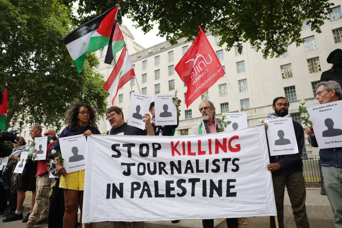 Manifestantes erguem faixa durante protesto pelas mortes de jornalistas na Faixa de Gaza | Foto: Toby Shepheard/AFP