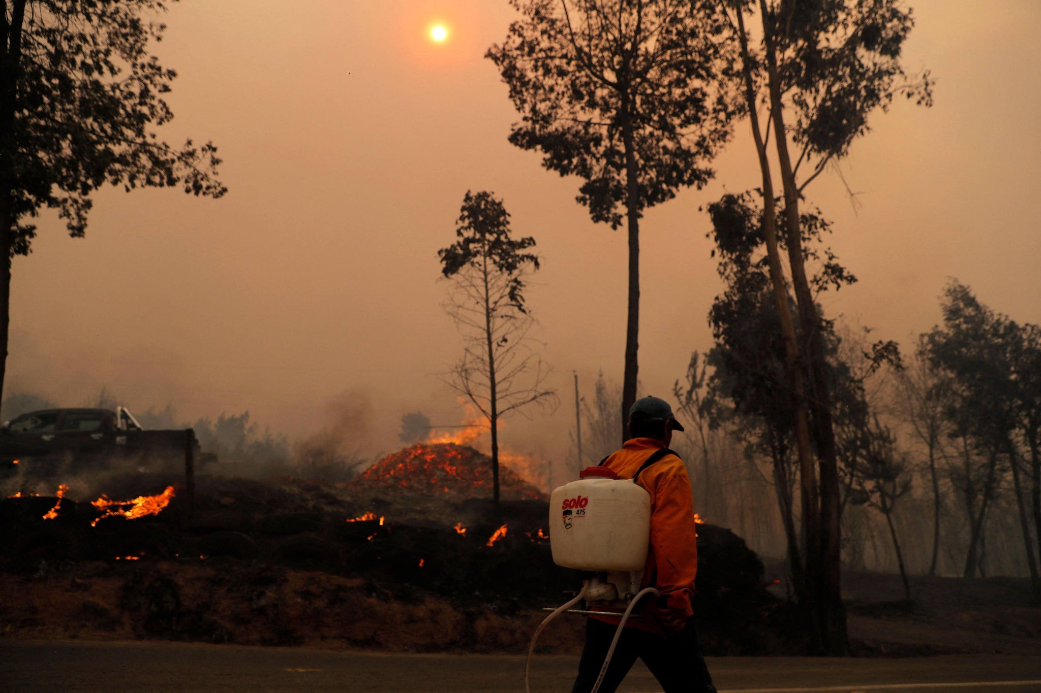 Homem combate incêndio em Santa Juana, no Chile, em fevereiro de 2024