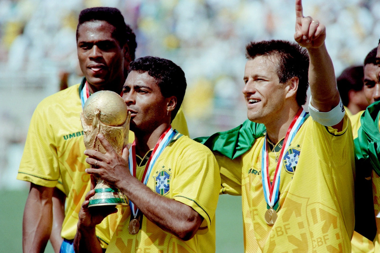 Romário beija a taça da Copa do Mundo, ao lado de Ronaldo (esq.) e Dunga (dir.), em 17 de julho de 1994 