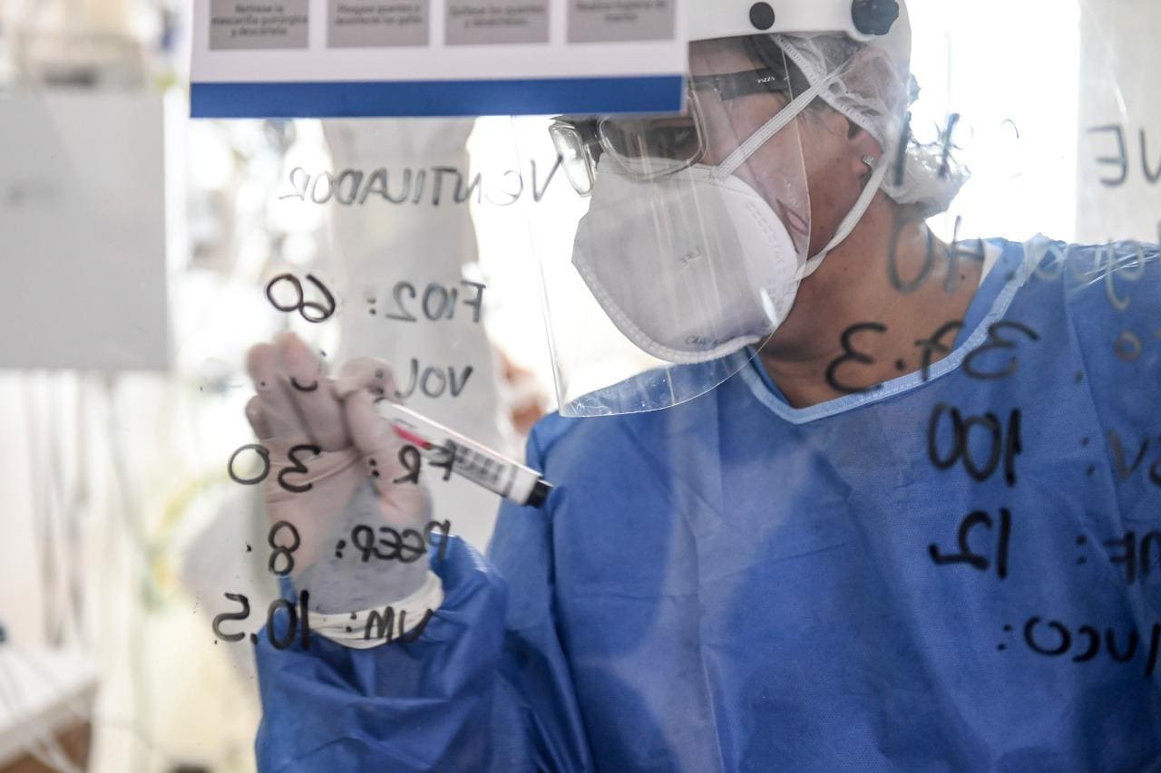 Na UTI de um hospital em Medellín na Colômbia, enfermeira escreve anotações em um painel após analisar a evolução do tratamento de um paciente com covid -19