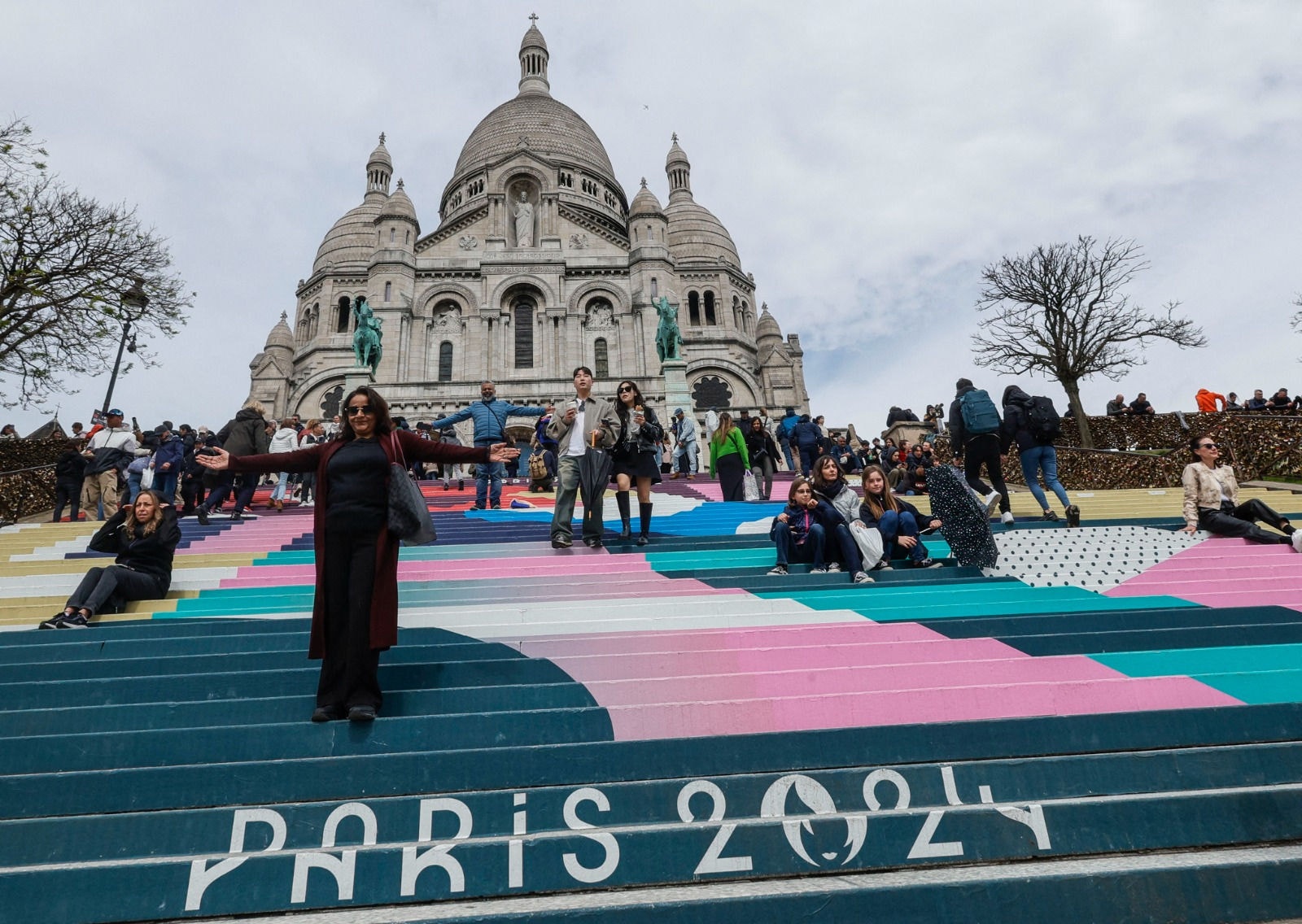 Turistas contemplam Paris das escadarias da Basílica do Sacré-Coeur, no bairro de Montmartre, no ponto mais alto da cidade