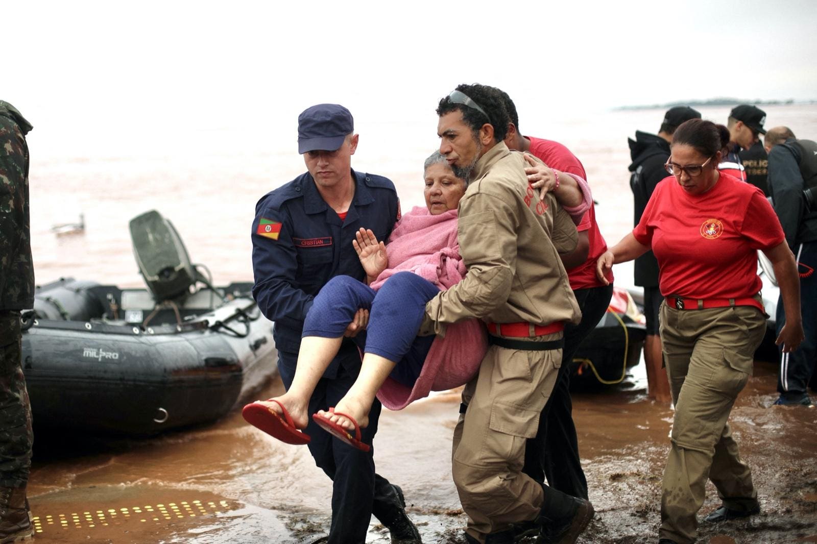 Uma equipe de resgate carrega uma mulher em Porto Alegre, Rio Grande do Estado, Brasil, em 4 de maio de 2024. As enchentes causadas pelas intensas chuvas que atingiram o sul do Brasil deixaram pelo menos 57 mortos e 67 desaparecidos, segundo novo relatório de sábado da Defesa Civil