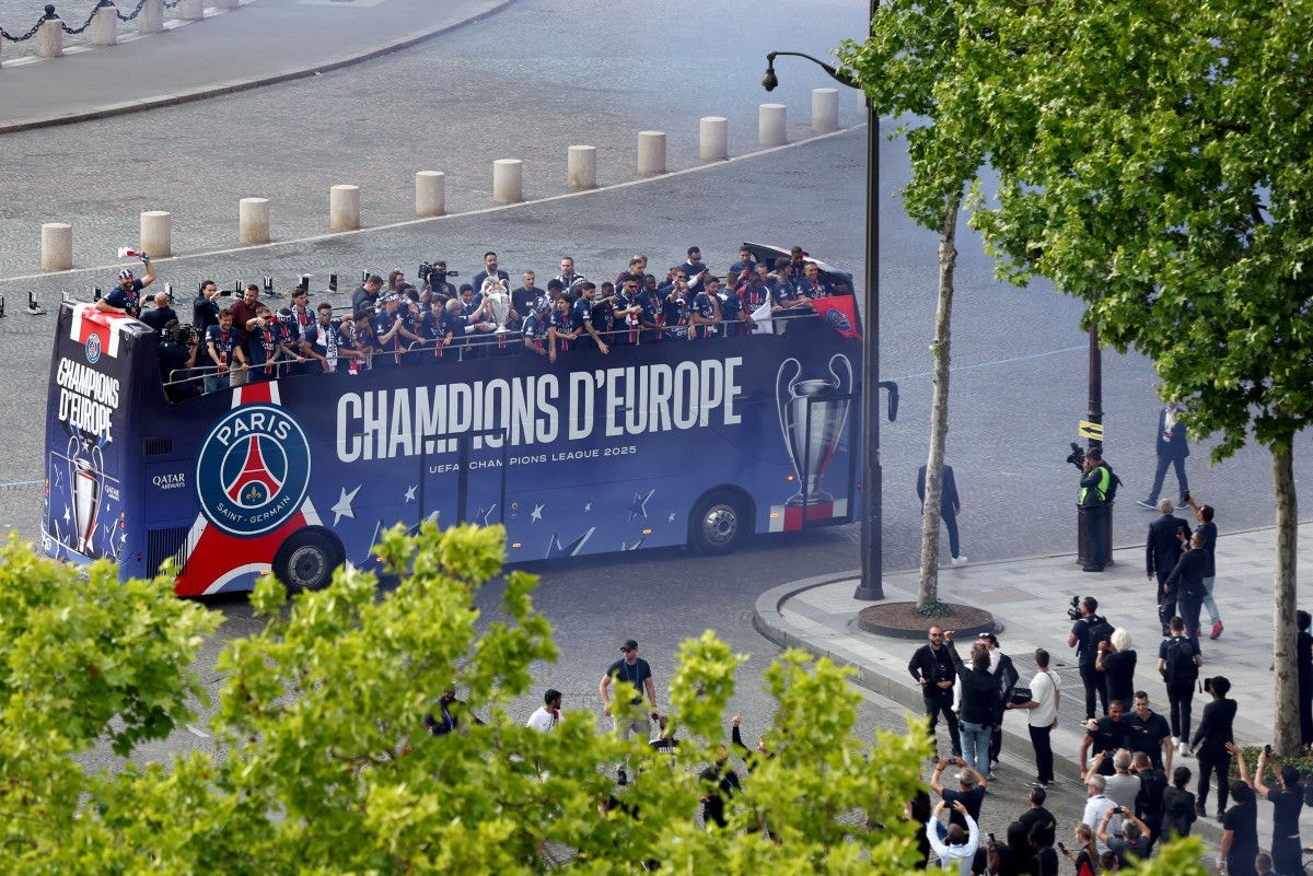 Paris Saint-Germain's players celebrate with the trophy during a parade on the Champs-Elysees avenue in Paris on June 1, 2025, a day after PSG won the 2025 UEFA Champions League final football match against Inter Milan in Munich. (Photo by Romain PERROCHEAU / AFP)