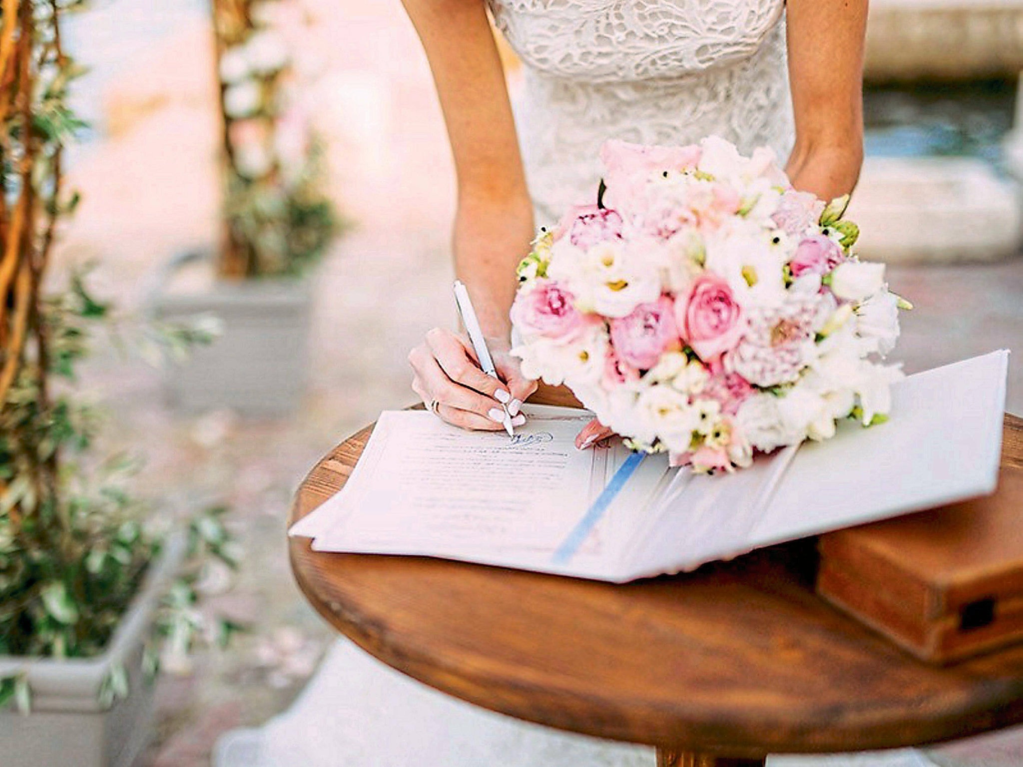 Mulher assinando documento durante casamento no religioso