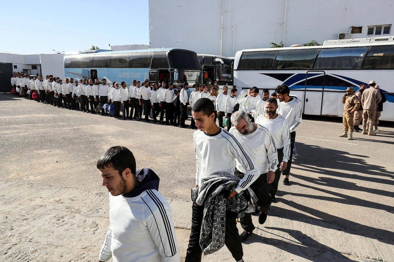 Migrantes egípcios chegam durante uma operação de deportação levada a cabo pelo governo baseado em Trípoli, na capital líbia, em 12 de dezembro de 2023