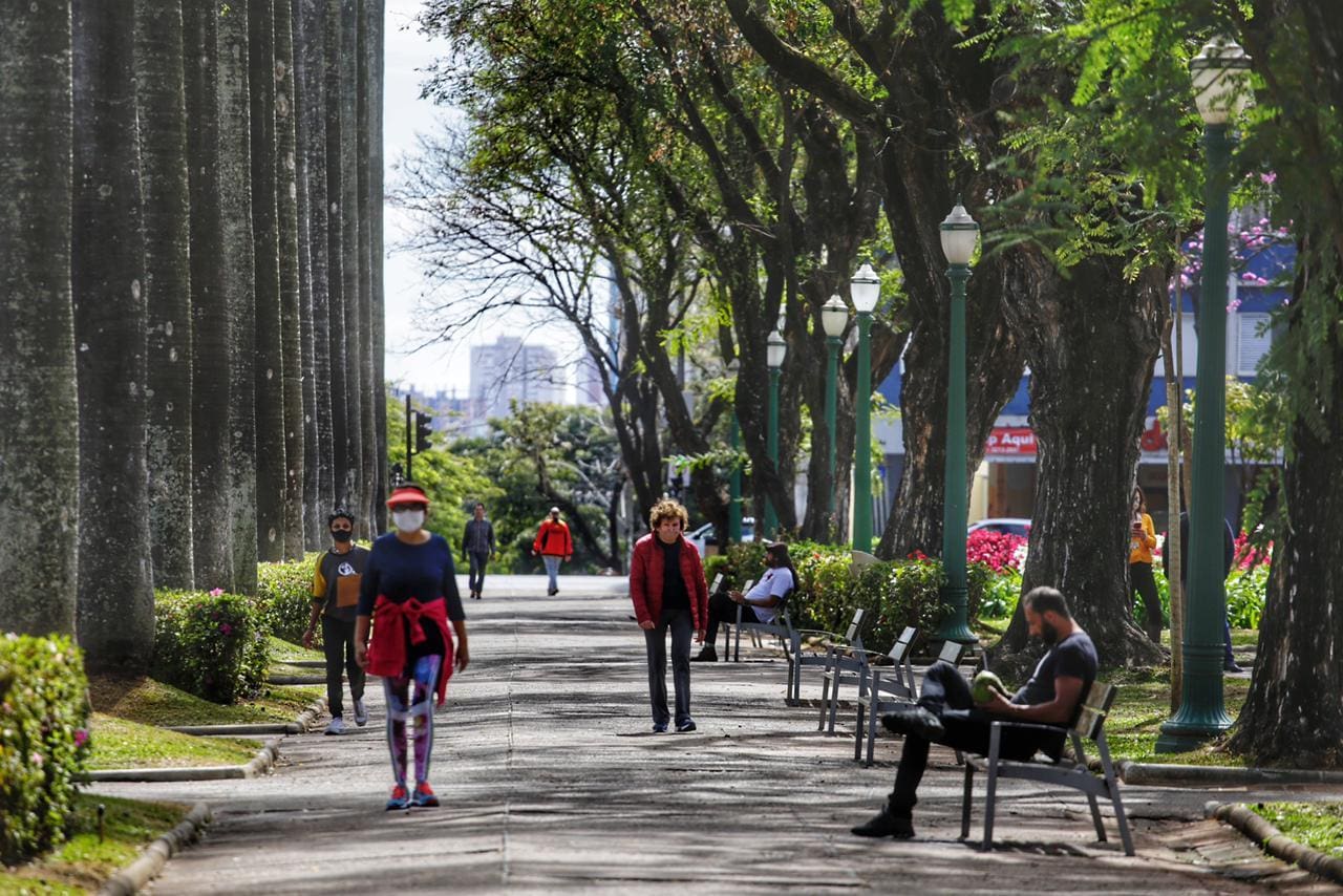 Imagem mostra pessoas com blusas de frio na Praça da Liberdade