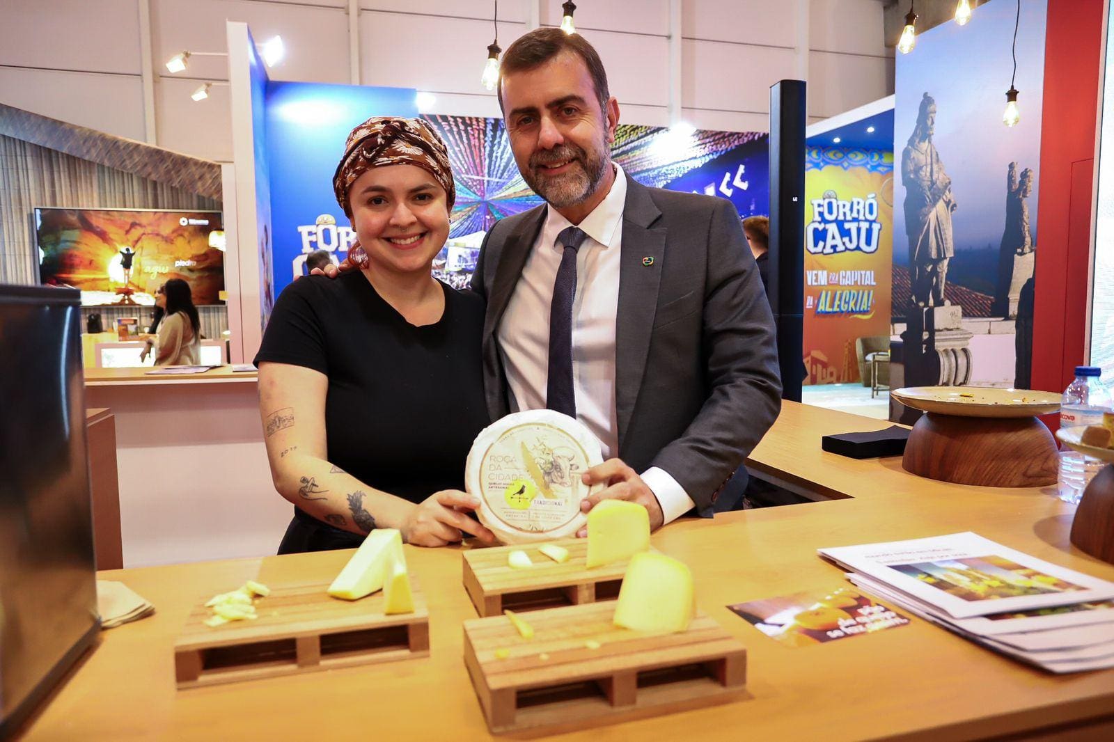 A chef Roberta Gomes e o presidente da Embratur, Marcelo Freixo, com o queijo Canastra no estande de Minas Gerais na feira BTL