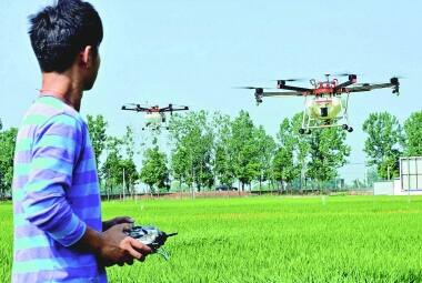 Agricultura na China. Morador de região rural do país pilota drones para pulverizar pesticida em plantação numa aldeia em Poyang