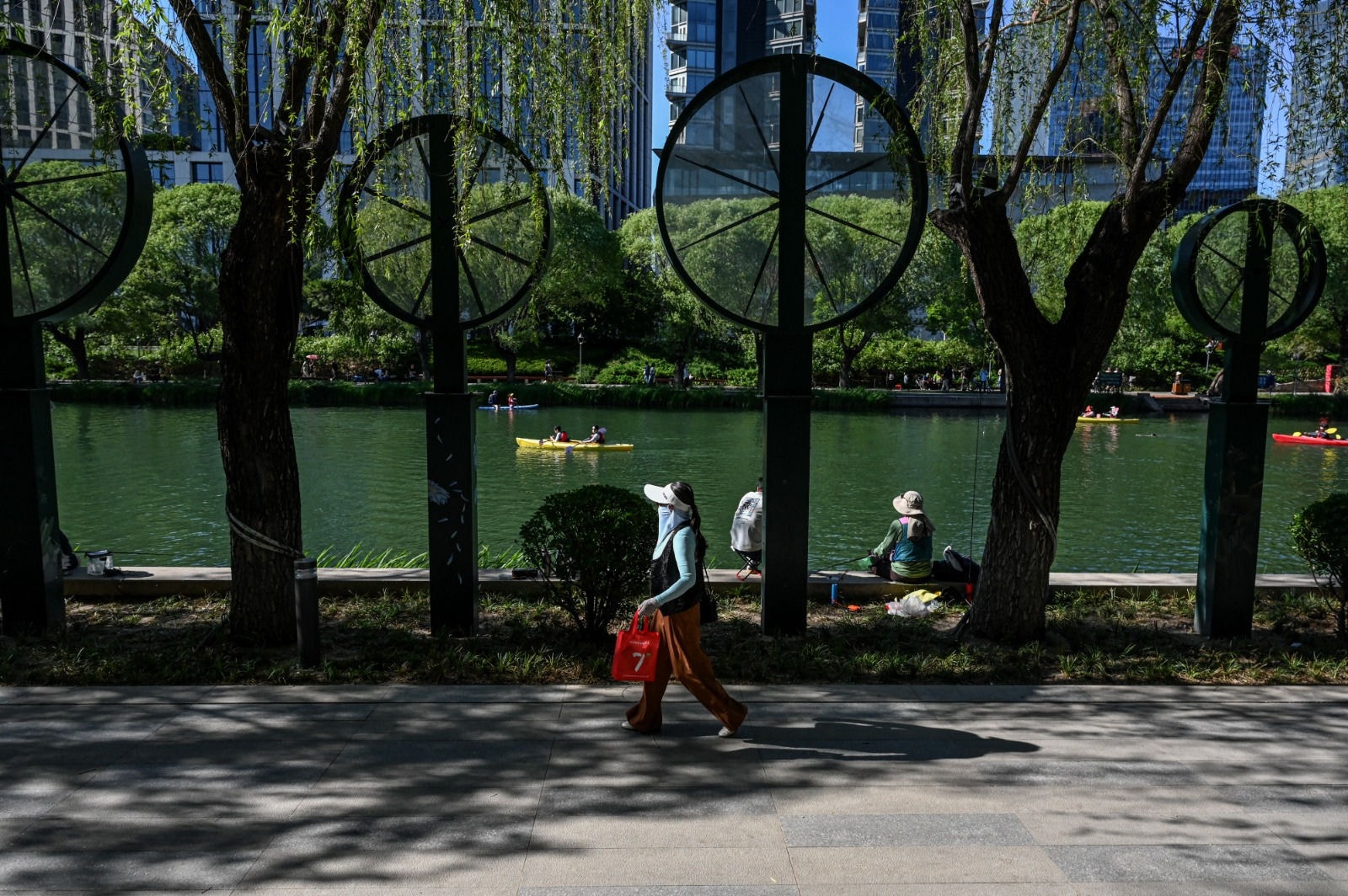 Uma mulher caminha ao longo de um canal em Pequim, uma das cidades-esponja da China 