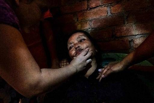 Mulher ferida durante protestos em Myanmar recebe socorro