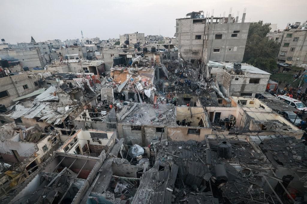 Palestinos observam área destruída em Rafh, ao Sul de Gaza