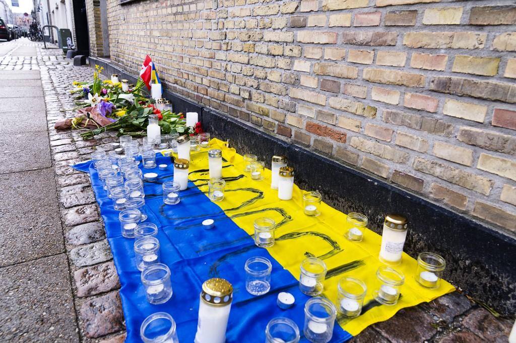 Velas são colocadas em uma bandeira ucraniana em frente à Embaixada da Ucrânia em Copenhague, Dinamarca, em 25 de fevereiro de 2022, em solidariedade ao povo ucraniano depois que seu país foi invadido pela Rússia
