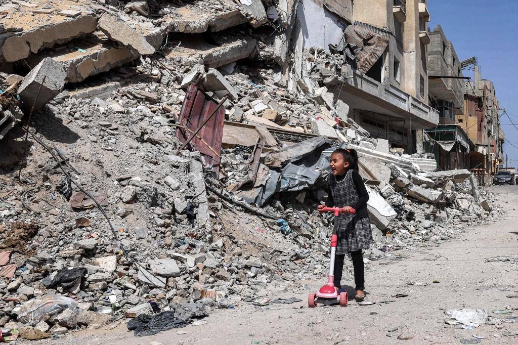 Criança palestina brinca em meio à destruição em Rafah