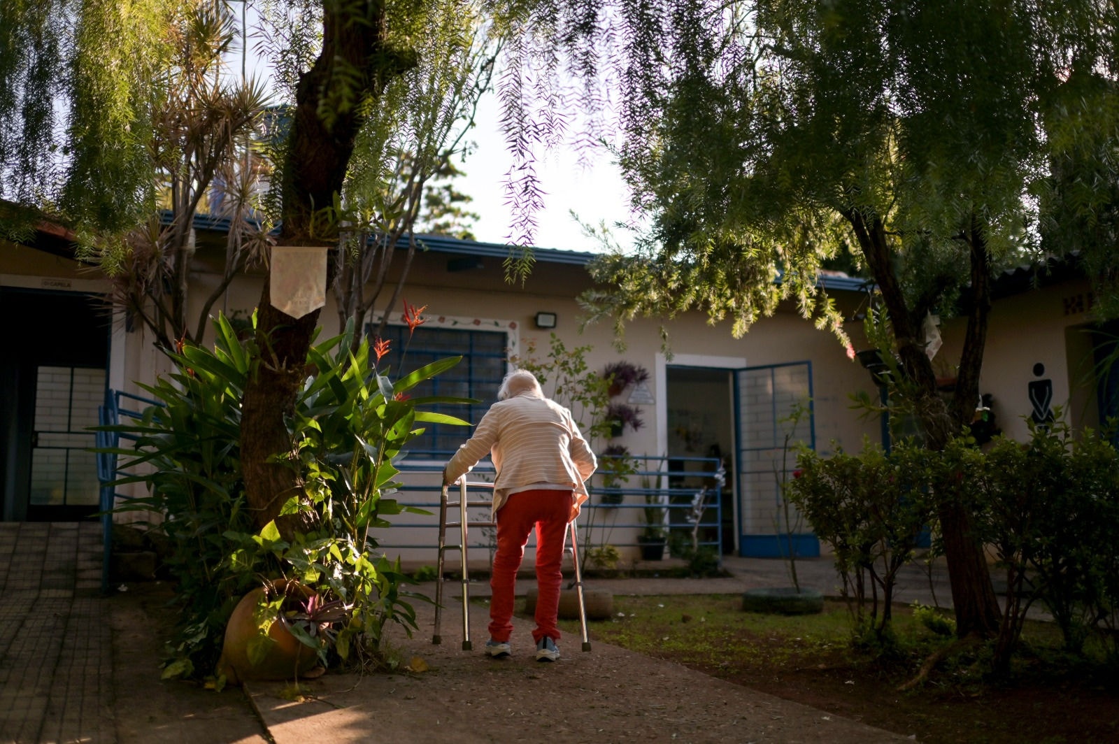 Idosa caminhando no jardim
