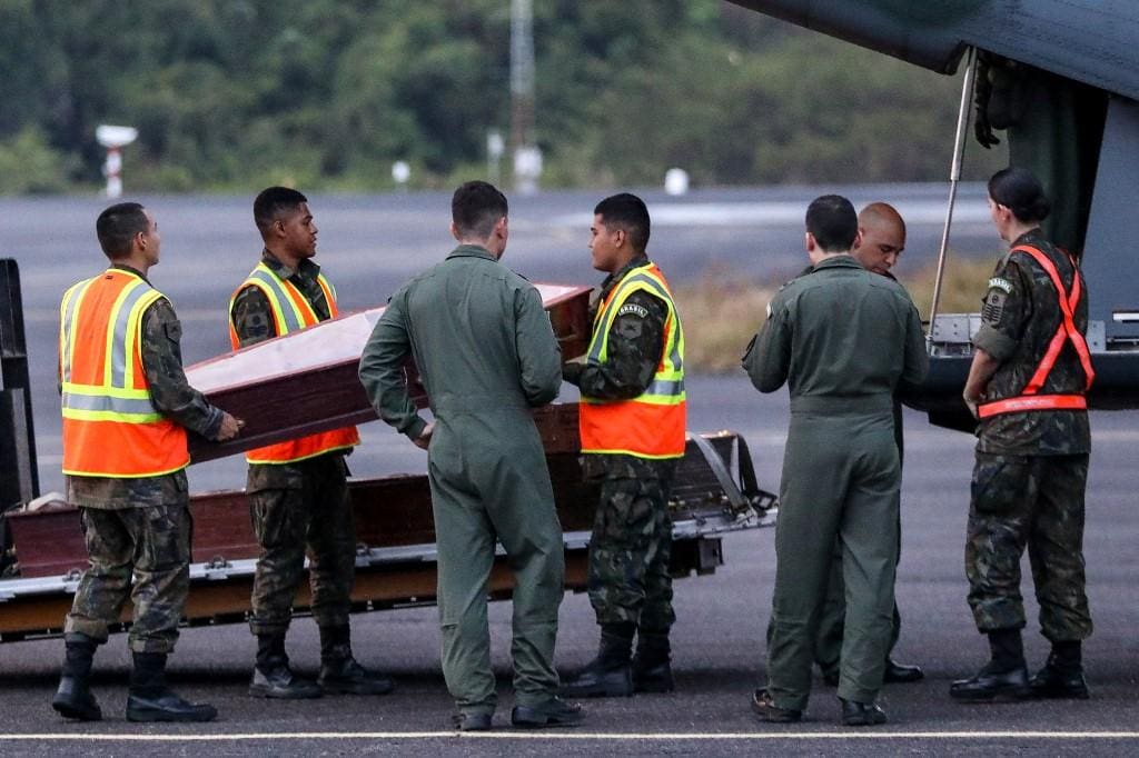 Militares brasileiros carregam caixões na Base Aérea de Manaus (AM) em um avião da FAB para resgatar os corpos das 14 pessoas que morreram durante o pouso de um avião em Barcelos