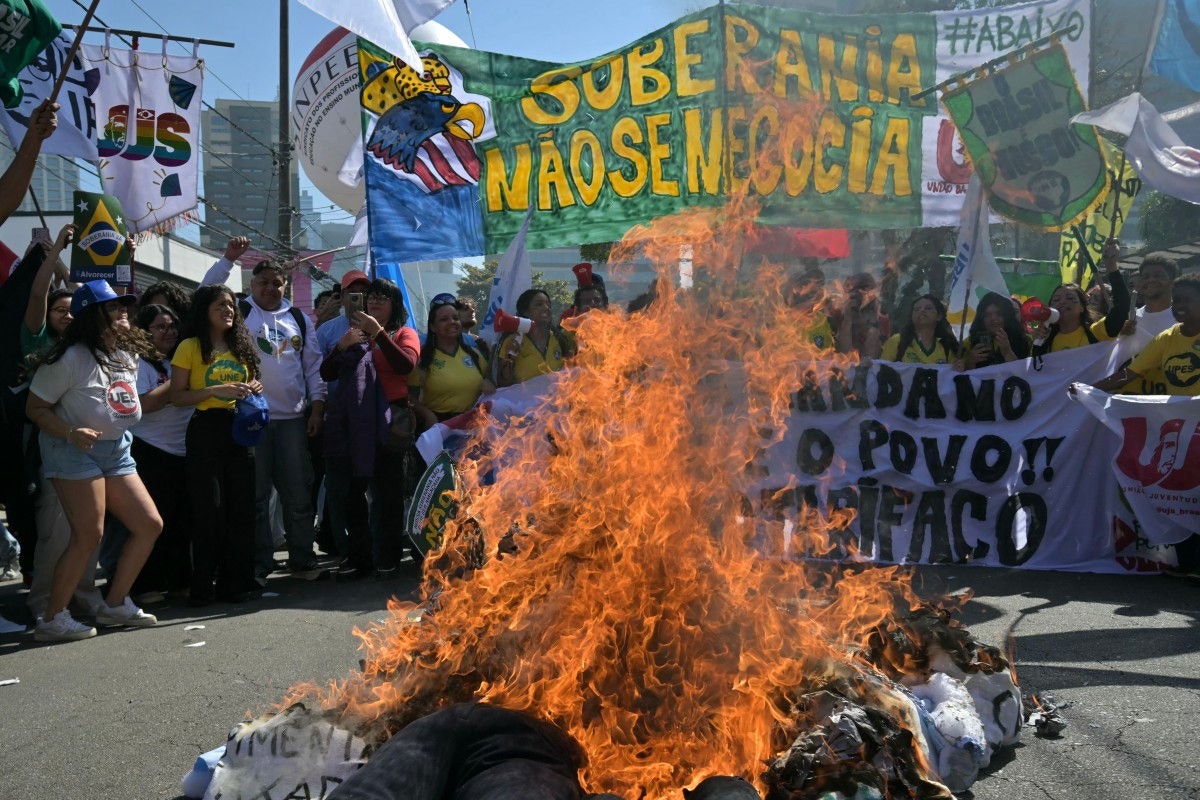 Manifestantes queimam bonecos de Donald Trump e Jair Bolsonaro, em frente ao consulado norte-americano, na zona sul de São Paulo, em protesto contra tarifaço e pela soberania brasileira