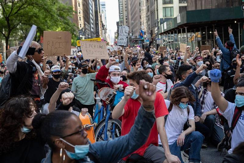 Os manifestantes da Black Lives Matter se ajoelham para homenagear George Floyd no centro de Manhattan, em Nova York