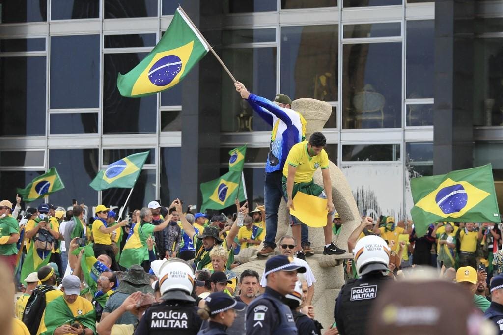 Mesmo diante de policiais militares, radicais subiram na estátua da Justiça, invadiram e destruíram o prédio do STF