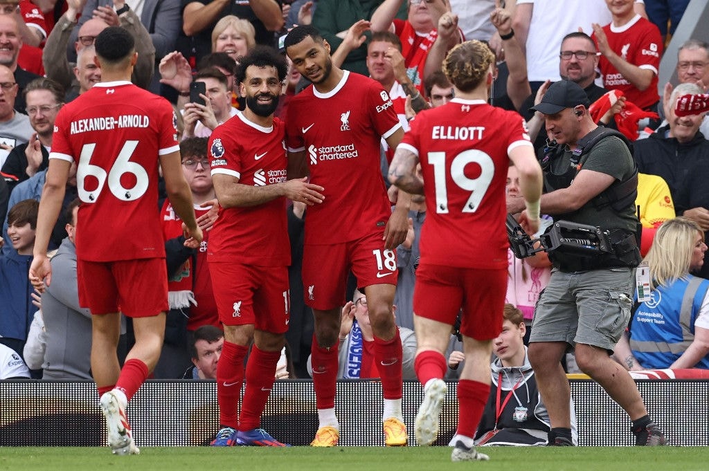 Liverpool's Dutch striker #18 Cody Gakpo (C) celebrates scoring the team's third goal with Liverpool's Egyptian striker #11 Mohamed Salah (2L) during the English Premier League football match between Liverpool and Tottenham Hotspur at Anfield in Liverpool, north west England on May 5, 2024. (Photo by Darren Staples / AFP) / RESTRICTED TO EDITORIAL USE. No use with unauthorized audio, video, data, fixture lists, club/league logos or 'live' services. Online in-match use limited to 120 images. An additional 40 images may be used in extra time. No video emulation. Social media in-match use limited to 120 images. An additional 40 images may be used in extra time. No use in betting publications, games or single club/league/player publications. / 