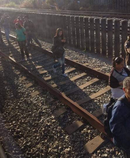 Passageiros caminham pelos trilhos após falha no trem