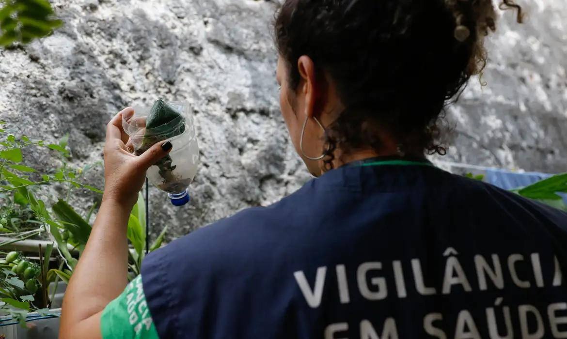 Integrante da vigilância sanitária observa focos para o mosquito Aedes aegypti