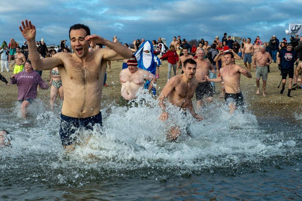 Desafiando temperaturas da água de cerca de seis graus, os nadadores mergulharam ao som de gaitas
