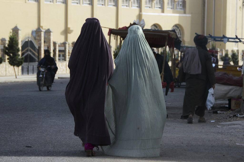 Mulheres usando burcas, com o corpo totalmente coberto, caminham pelas ruas de Kandahar, no Afeganistão, onde o Talibã ordenou restrições pesadíssimas às muheres