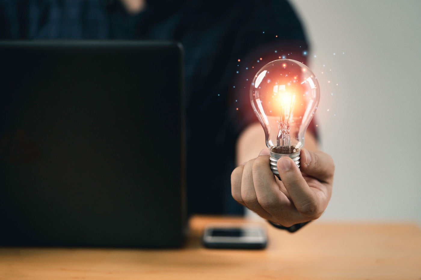 Businessman hand holding lightbulb with glowing light to creative smart thinking for inspiration and innovation with network concept.