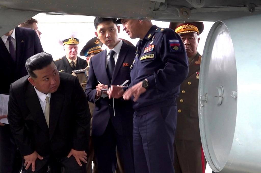 O líder norte-coreano Kim Jong-un se agacha para inspecionar bombardeiro das forças nucleares russas em Vladivostok