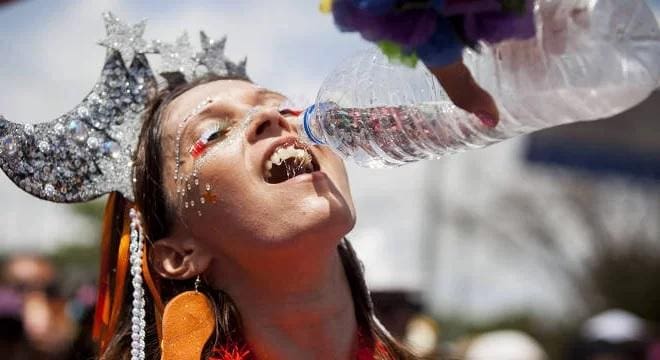 Mulher bebe água durante o Carnaval (imagem ilustrativa)