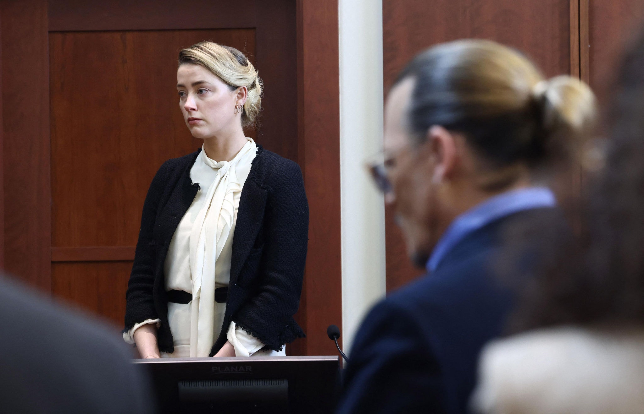 Amber Heard testemunha enquanto Johnny Depp a observa durante um julgamento