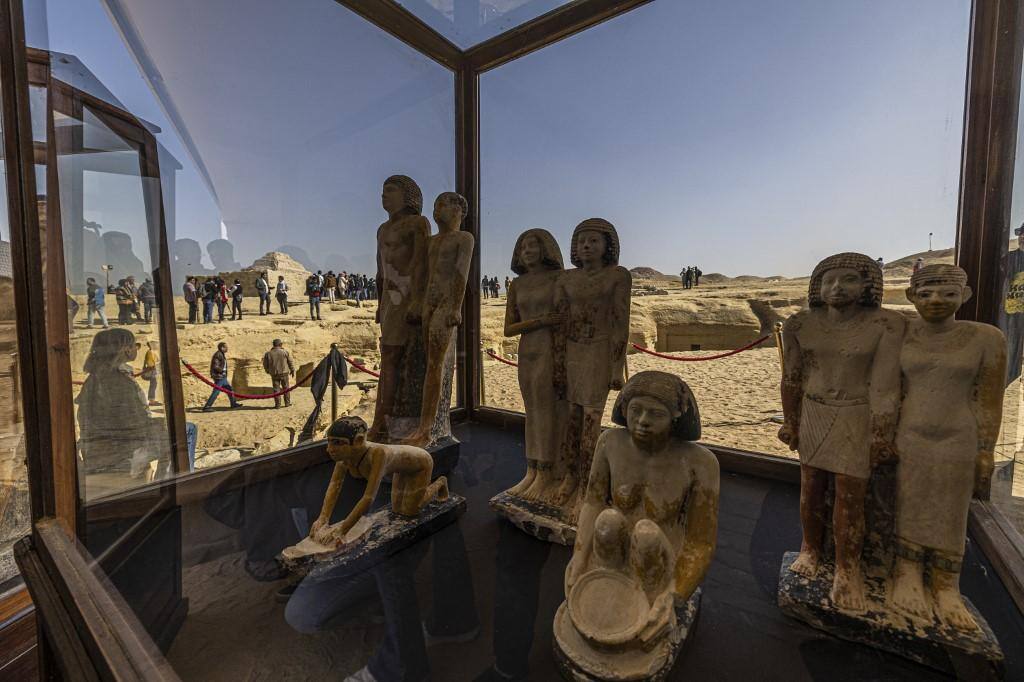 Um arqueólogo egípcio restaura antiguidades no sítio arqueológico de Saqqara, onde uma múmia revestida de ouro e quatro túmulos, incluindo o "guardião do segredo" de um antigo rei, foram descobertos, ao sul do Cairo em 26 de janeiro de 2023