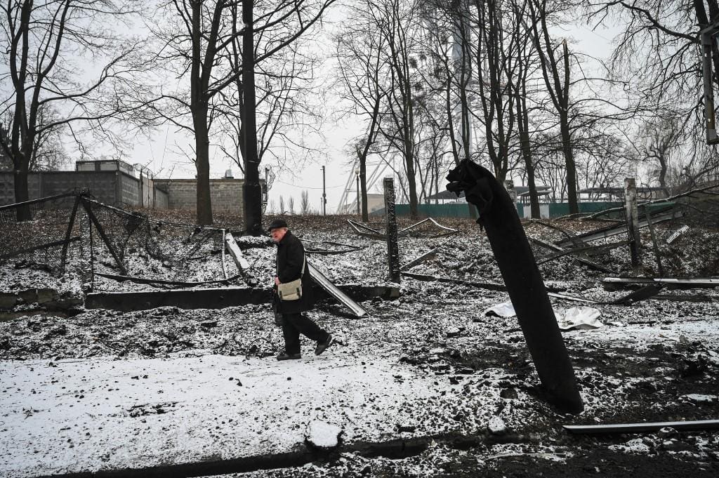 Um idoso passa pelos destroços de um prédio após bombardeios em Kiev em 2 de março de 2022