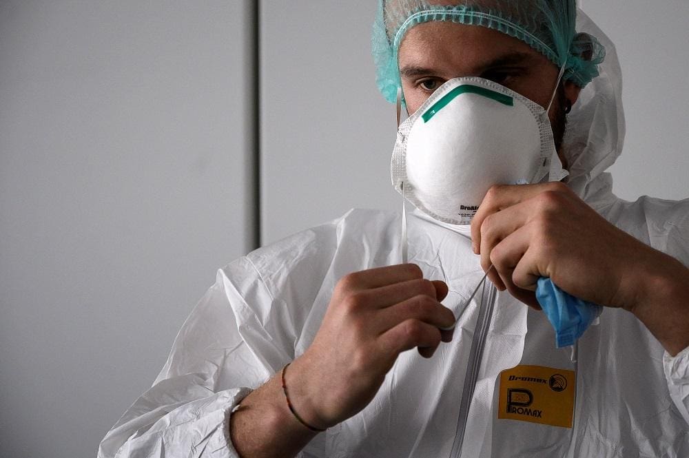 Enfermeira coloca seu equipamento de proteção pessoal (EPI) antes de começar a trabalhar na preparação da unidade de terapia intensiva no novo hospital Covid-19 em Verduno, perto de Alba, no noroeste da Itália