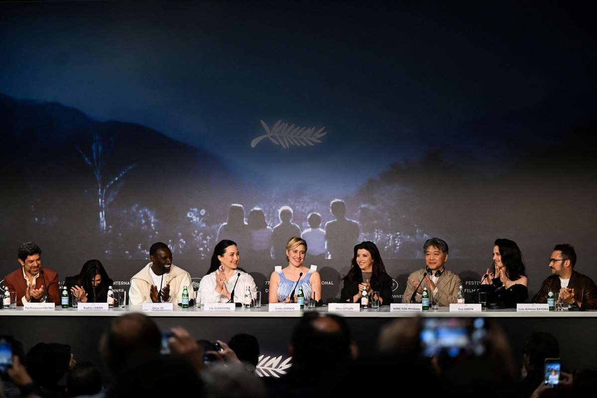 A diretora norte-americana e presidente do júri do 77º Festival de Cinema de Cannes, Greta Gerwig (C), é aplaudida pelo ator italiano Pierfrancesco Favino, pela diretora libanesa Nadine Labaki, pelo ator francês Omar Sy, pela atriz norte-americana Lily Gladstone, pelo escritor e fotógrafo turco Ebru Ceylan , o diretor japonês Hirokazu Kore-eda, a atriz francesa Eva Green e o diretor, produtor e escritor espanhol Juan Antonio Bayona durante coletiva de imprensa do Júri em Cannes