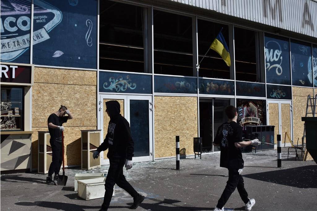 Moradores da cidade de Zaporizhzhya protegem vidros de lojas, após ataques com drones