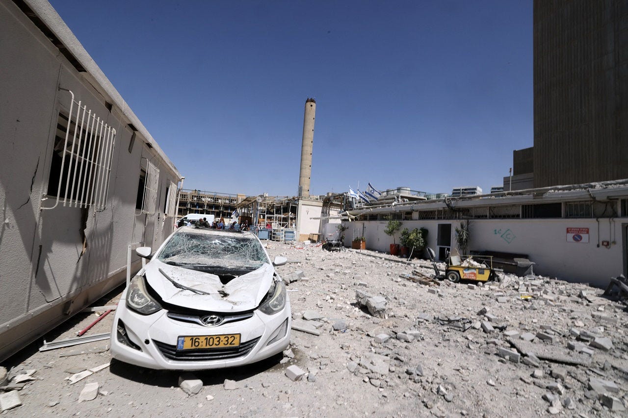 A damaged car sits amid debris outside the Soroka Hospital in the southern city of Beersheba, after it was hit by a missile fired from Iran on June 19, 2025. Israel's defence minister warned that Iran's supreme leader "can no longer be allowed to exist" after a hospital was hit in an Iranian missile strike on June 19, spiking tensions in the week-old war. (Photo by Marc Israel SELLEM / POOL / AFP)