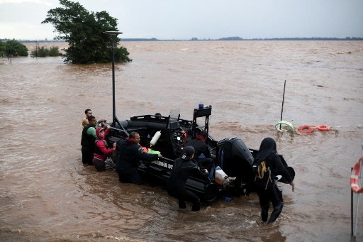 Brazil Navy officers dock their boat at an improvised port on Lake Guaiba as a storm brews in Porto Alegre, Rio Grande do Sul state, Brazil, on May 8, 2024. The death toll from devastating floods that have ravaged southern Brazil for days surpassed 100 on Wednesday, authorities said, as the search for dozens of missing people was interrupted by fresh storms. (Photo by Anselmo CUNHA / AFP)