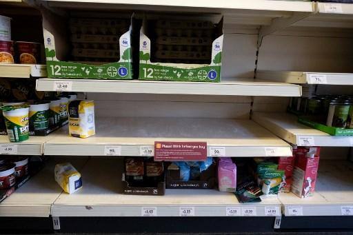 Prateleiras vazias onde os pacotes de farinha normalmente seriam estocados são mostradas abaixo de ovos meio vazios e estoques de açúcar, dentro de uma loja de supermercados de Sainsbury, no norte de Londres