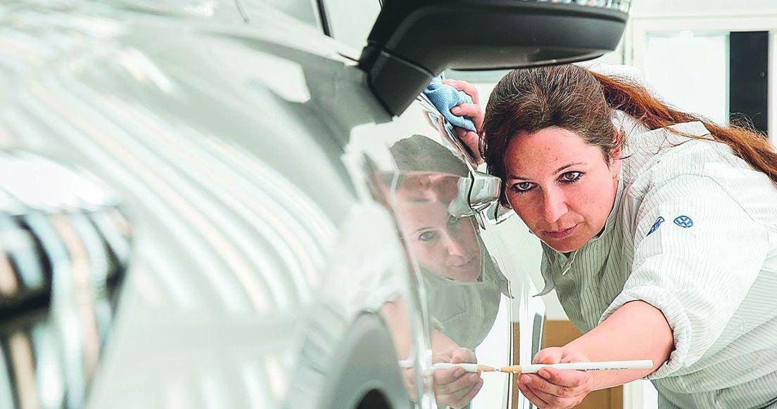 Colaboradora da VW verifica a qualidade da pintura de um modelo na fábrica da marca alemã